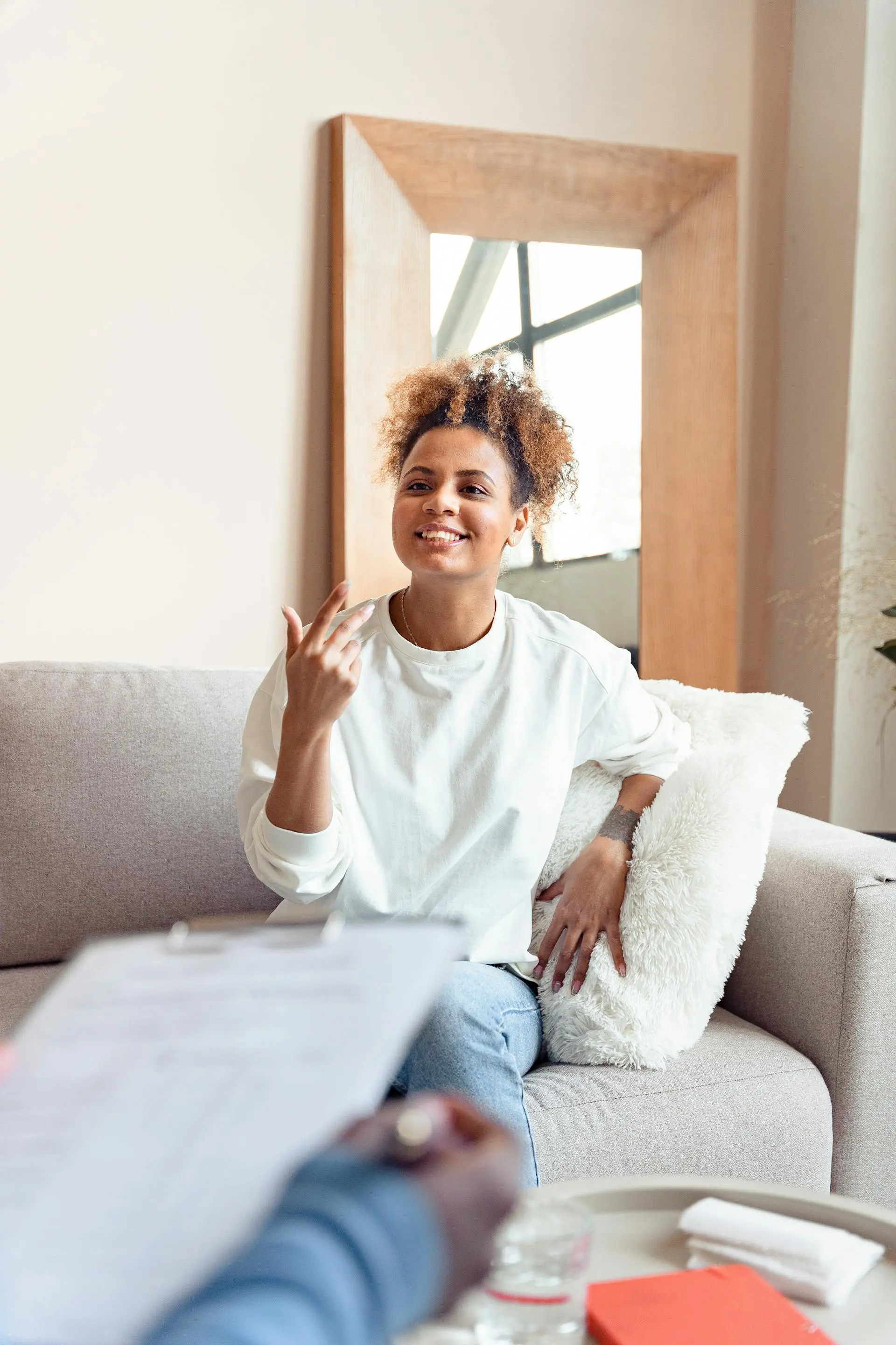 Woman sitting on a couch smiling and talking